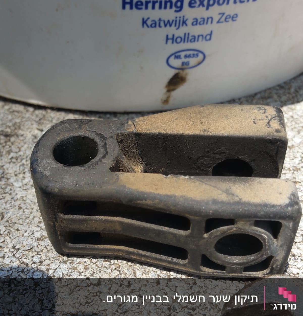 A metal frame with holes and a wrench on a textured surface.